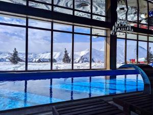 古道里的住宿－GVC 3-room 2-level apt New Gudauri，享有雪覆盖山脉景致的游泳池