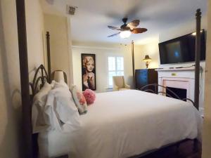 a bedroom with a white bed with a fireplace and a television at Villa Mulvey # 5 in St. Augustine