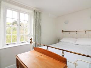 a bedroom with a bed and a window at Coastguard Cottage in Dartmouth