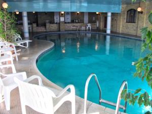 a swimming pool in a hotel with white chairs at Sandringham Hotel - Seafront, Sandown, Isle of Wight - FREE CAR FERRY TICKET for 3 Nts, 1-2 Nts from 109 Pounds in Sandown
