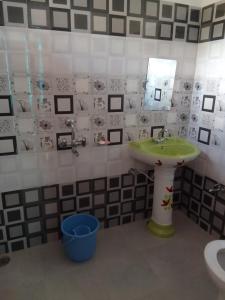 a bathroom with a green sink and a mirror at Samaira home stay in Bīr