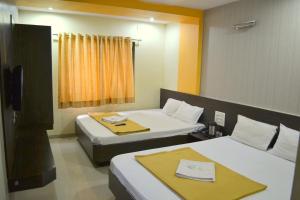 Hotel Sai Kamal tesisinde bir odada yatak veya yataklar