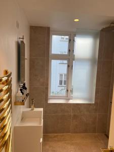 a bathroom with a shower with a sink and a window at Luxury new apartment - Heart of Copenhagen in Copenhagen