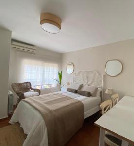 ein Schlafzimmer mit einem großen weißen Bett und zwei Spiegeln in der Unterkunft Apartamento de Temporada en Madrid in Madrid