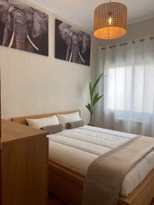 a bedroom with a bed with two posters of elephants at Las Meninas de Cavero in Madrid