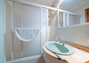 a bathroom with a glass shower and a sink at Record Maritim II in Port d'Alcudia