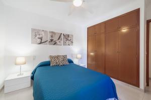 a bedroom with a blue bed and a wooden cabinet at Record Maritim II in Port d'Alcudia
