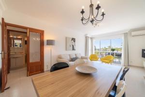 a dining room and living room with a table and chairs at Record Maritim II in Port d'Alcudia