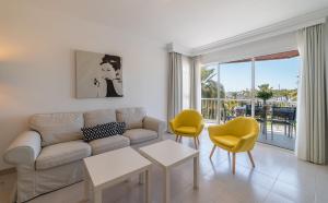 a living room with a couch and two yellow chairs at Record Maritim II in Port d'Alcudia