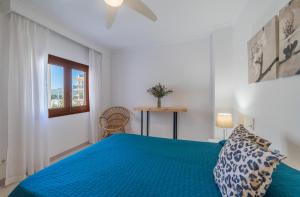 a bedroom with a blue bed and a window at Record Maritim II in Port d'Alcudia