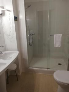 y baño con ducha, aseo y lavamanos. en Hôtel Les Deux Magots, en La Roche-Bernard