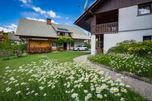 a lawn with flowers in front of a house at Apartma BioFit Bled in Bled