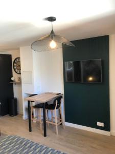 a dining room with a table and a tv at Concarneau centre-ville proche plage in Concarneau