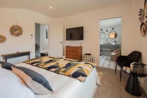 ein Schlafzimmer mit einem Bett und einem TV an der Wand in der Unterkunft SOUS LE TILLEUL à RUOMS in Ruoms