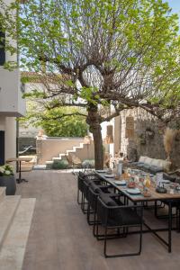 eine Terrasse mit einem Tisch und Stühlen unter einem Baum in der Unterkunft SOUS LE TILLEUL à RUOMS in Ruoms