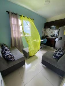 a living room with two couches and a yellow net at RESIDENCIAL DOÑA GLORIA in San Felipe de Puerto Plata