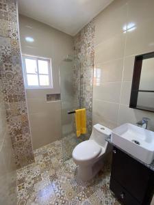 y baño con aseo, lavabo y ducha. en RESIDENCIAL DOÑA GLORIA en San Felipe de Puerto Plata