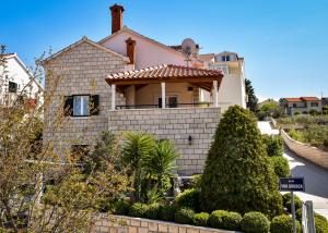 a white house with a tile roof at Apartmani Etica in Postira