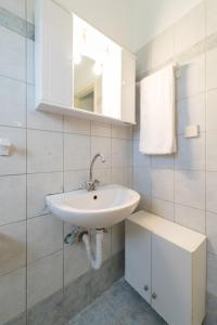 La salle de bains blanche est pourvue d'un lavabo et d'un miroir. dans l'établissement SPIROS HOME, à Lixouri
