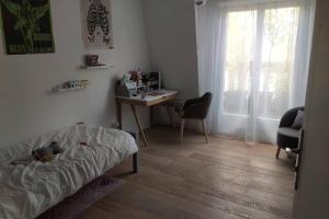 a room with a bed and a desk and a table at Appartement Cosy et Moderne Puteaux Paris La Defense in Puteaux