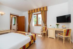 a hotel room with a bed and a desk and a television at Villa Królewiec - 1,5km od Energylandii in Zator