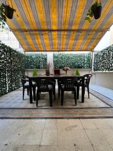 eine Terrasse mit einem Tisch und Stühlen unter der Decke in der Unterkunft MiRhome Apartment in Rom