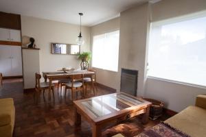 Una sala de estar con una mesa y un comedor. en Casa grande y cómoda en el centro de Esquel, en Esquel