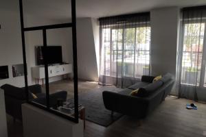 a living room with a couch and a mirror at Appartement Cosy et Moderne Puteaux Paris La Defense in Puteaux