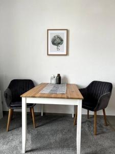 a dining room table with two chairs and a picture at ~In der Natur und dennoch zentral~ in Annaberg-Buchholz