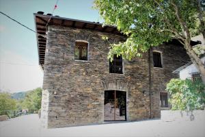 a stone building with windows on the side of it at Casa Rural Estrella del Sil in Corbón del Sil