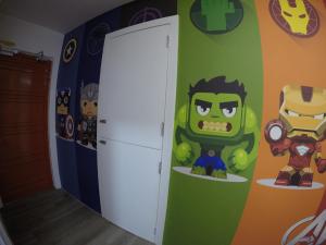 a room with a superhero mural on the wall at CoCo Guesthouse Kemaman in Cukai