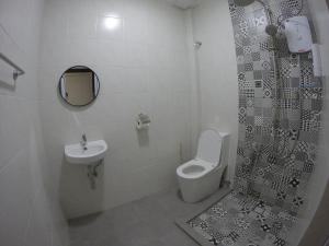 a bathroom with a toilet and a sink and a shower at CoCo Guesthouse Kemaman in Cukai