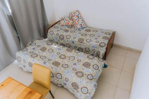 ein kleines Schlafzimmer mit einem Bett und einem Stuhl in der Unterkunft La Tranquila in Pergamino