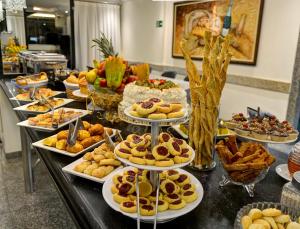 a buffet with many plates of food on a table at Porto Minas Hotel e Convenções in Uberlândia