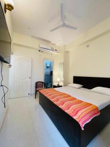a bedroom with a large bed with a striped blanket at Uprè in Varanasi