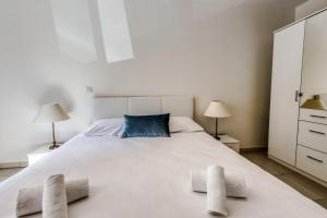 a bedroom with a large white bed with two pillows at Appartement Clap d'Or - Welkeys in Cannes