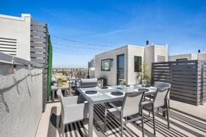a patio with a table and chairs on a balcony at LA #FleetWeek Home with Private Rooftop near #DTLA in San Pedro