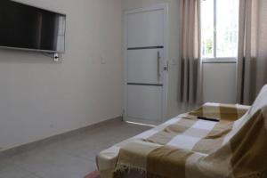 Zimmer mit einem Bett, einem TV und einem Fenster in der Unterkunft Casa com Spa de Hidro com aquecedor a 700 mts do centro in Chapada dos Guimarães