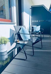 a chair sitting on a porch with two pillows at Ferienwohnung Sunside im Herzen von Winterberg in Winterberg