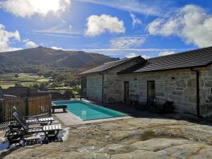 a stone building with a swimming pool and a house at Casa da Avó Ana Alvão in Bilhó
