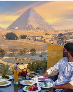 two men sitting at a table with a view of the pyramids at Pyramids Sun Capital in Cairo