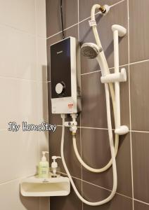 a shower in a bathroom with a white hose at JRv HotelStyle HomeStay Melaka in Malacca