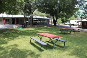 zwei Picknicktische und eine Bank in einem Park in der Unterkunft Wapiti Lodge in Durango