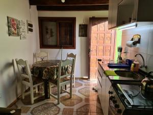 a kitchen with a table and chairs in a kitchen at Cabañas Los Ñatos SE RESERVA CON SEÑA !!! in Barra del Chuy