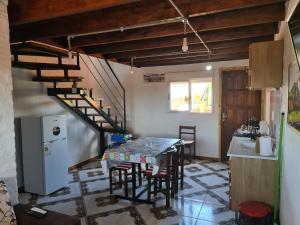 a kitchen with a table and a spiral staircase at Cabañas Los Ñatos SE RESERVA CON SEÑA !!! in Barra del Chuy