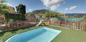 uma piscina num quintal com um parque infantil em Casa rural Molino Pataslargas em Cotillas