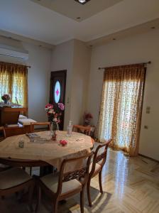 a dining room with a table and chairs and curtains at With a View of Meteora in Diáva