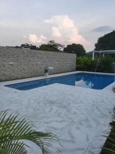 a swimming pool in a yard with a tile floor at ALMA VILLAGE CASA CAMPESTRE MARIQUITA in Guayabal