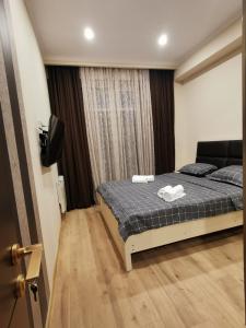 a bedroom with a bed with two towels on it at ArchiC509 in Tbilisi City