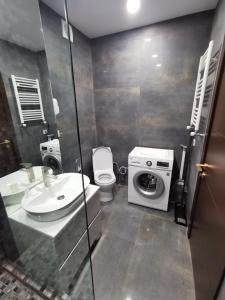 a bathroom with a toilet sink and a washing machine at ArchiC509 in Tbilisi City